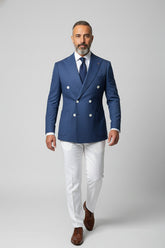 Man in blue double-breasted suit with white trousers, perfect for upscale events.